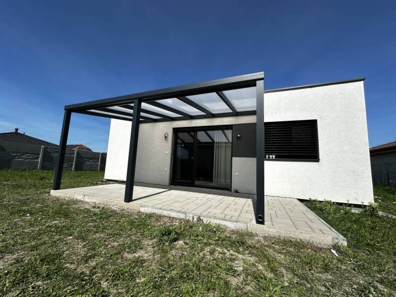 Štýlový hliníkový prístrešok harmonicky dopĺňa architektúru domu
